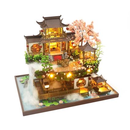 Miniatúrny drevený domček s osvetlením zobrazuje čínsku architektúru. Nachádza sa na podstavci s imitáciou vodopádu a kvetín. Domček má viacero poschodí a pavilónov.
