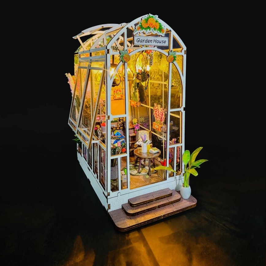 Miniatúrny skleník s názvom „Garden House“ zobrazuje vnútorný priestor s nábytkom a kvetinami. Je osvetlený a má schodíky pri vchode.