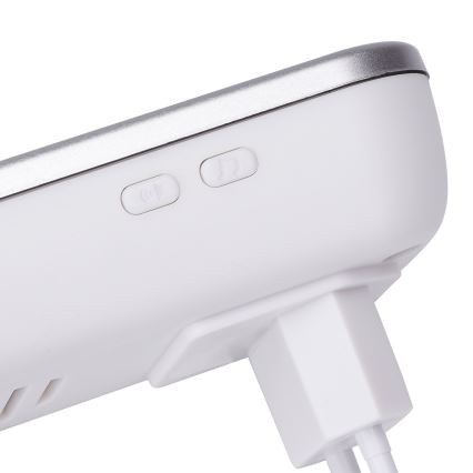 Biely bezdrôtový zvonček s dvoma tlačidlami: zapínanie/vypínanie a výber zvonenia. Zariadenie je pripojené k elektrickej zásuvke.