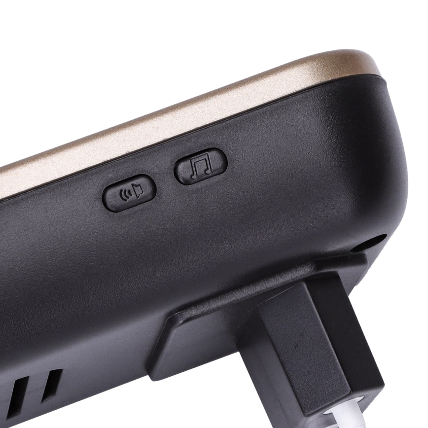 Zvoniaca jednotka s dvoma tlačidlami – jedno pre nastavenie hlasitosti a druhé pre výber melódie – je pripojená k elektrickej sieti. Má horný zlatý panel a čierny spodok.