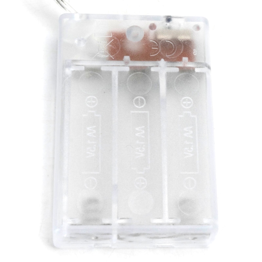 Priehľadný plastový držiak troch batérií typu 1,5 V s označením „V.C.1.5 V AA“ na každej. Batérie sú umiestnené v držiaku. Držiak je pravdepodobne súčasťou elektrického zariadenia.