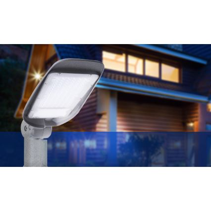 LED osvetľovacie teleso svieti. Je namontované na stĺpiku pred domom s dreveným obkladom, ktorý je v noci osvetlený z vnútra.