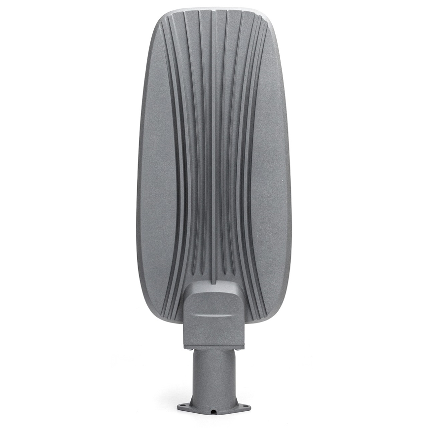 Sivá pouličná lampa s vertikálnymi drážkami na zadnej strane je umiestnená na krátkom stĺpiku. Lampa stojí na bielom pozadí.