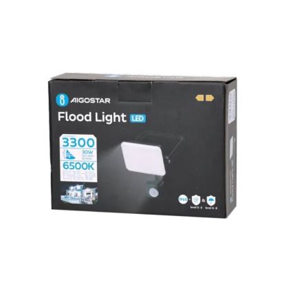 LED zaplavujúce svetlo AIGOSTAR svieti. Balenie zobrazuje svetlo s detektorom pohybu, technické údaje 3300 lúmenov, 30W, 6500K a triedou ochrany IP65. Na obale je ilustrácia použitia svetla na osvetlenie exteriéru.