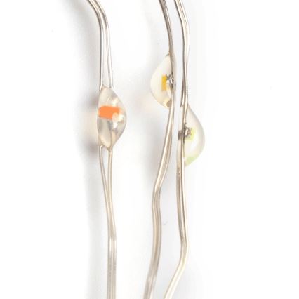 Svetlíková reťaz s LED diódami oranžovej, žltej a zelenej farby je natočená na bielom pozadí. Diódy sú zabudované v priesvitných krytoch.