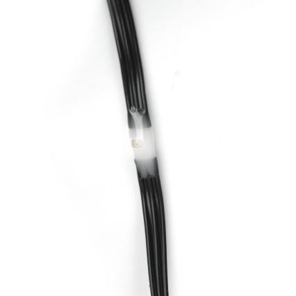 Čierny kábel s viacerými vodičmi je spojený priehľadnou zmršťovaciou bužírkou. Spojenie je umiestnené na bielom pozadí.