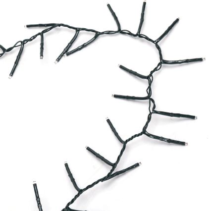 Svetelný reťaz s malými LED diódami je skrútený do vlnovky na bielom pozadí. Diódy sú pripojené k tenkému čiernemu káblu.