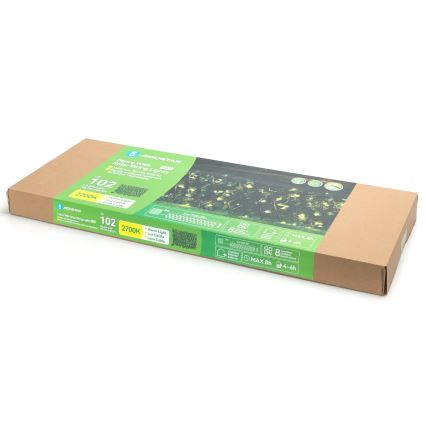 Kartónová krabica obsahuje plot s integrovanými solárnymi svetelnými reťazami. Na krabici je uvedený názov produktu „Fence With Solar String Lights“, model „102“, farba svetla „2700K“ a čas prevádzky „MAX 8h“.