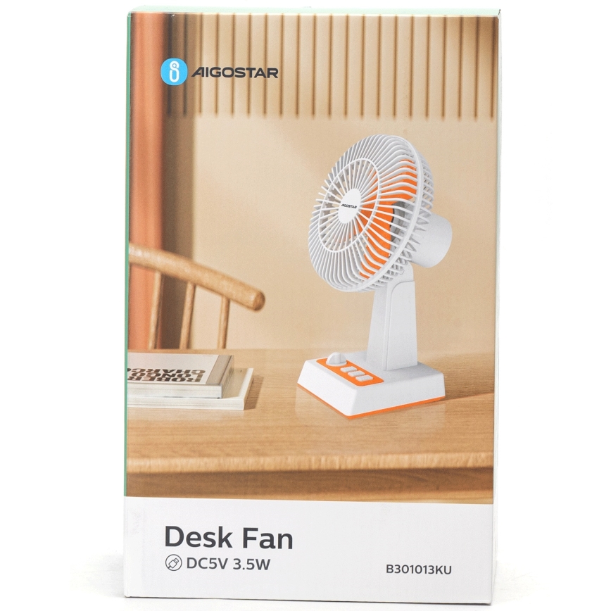 Stolný ventilátor s bielym telom a oranžovou základňou sa nachádza na drevenom stole. Ventilátor je zapnutý. Na krabici je uvedené: Desk Fan, DC5V 3.5W, B301013KU.