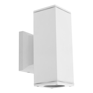 Biela nástenná lampa je pripevnená na stenu. Lampa svieti smerom dolu. Je umiestnená na bielom pozadí.