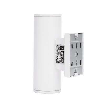 Biela nástenná lampa s valcovým telom je pripevnená k stene. Na zadnej strane je viditeľný montážny mechanizmus a štítok s údajmi: WALL LIGHT GU10 5W 230V~50Hz IP44 CLASS II 2023-03-22 MADE IN CHINA RoHS CE.