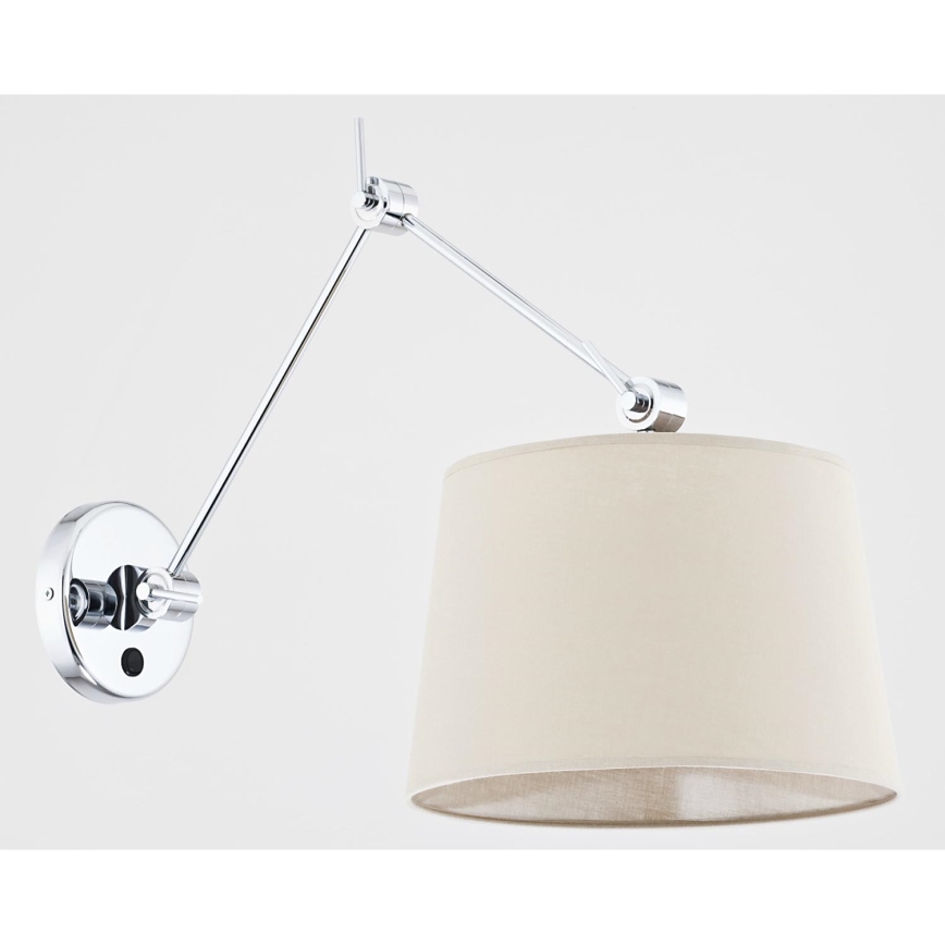 Nástenná lampa s chrómovým ramenom a béžovým tienidlom je pripevnená na stenu. Rameno umožňuje nastavenie smeru svetla. Tienidlo je valcovitého tvaru.