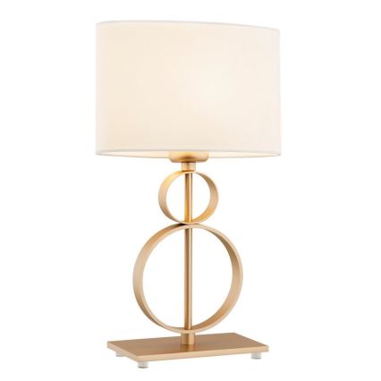 Stolová lampa s bielym tienidlom stojí na štvorcovej základni. Noha lampy je zlatej farby a pozostáva z prekrývajúcich sa kruhov.
