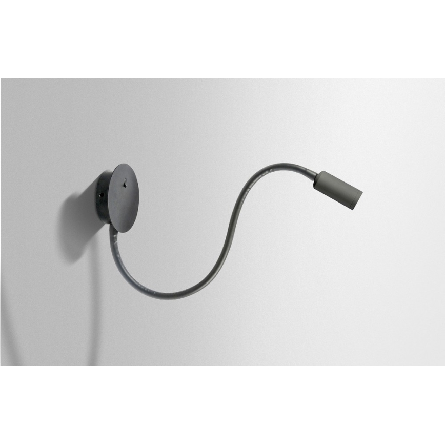 Nástenné svietidlo s ohybným ramenom je pripevnené k stene. Svietidlo smeruje doprava. Pozadie je svetlo sivá stena.