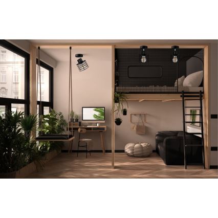 Závesné svietidlo s klietkovým tienidlom visí v interiéri s drevenou konštrukciou poschodovej postele a pracovným stolom. Na poschodí sú dve nástenné svietidlá. Priestor je zariadený rastlinami.