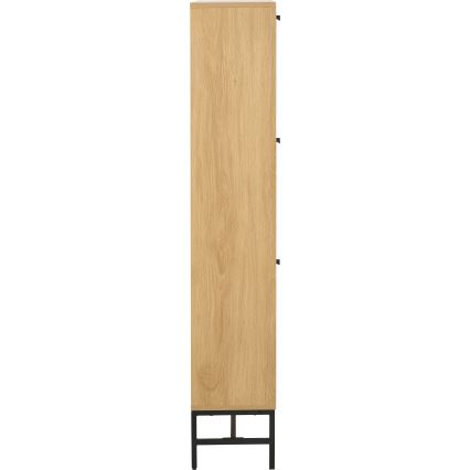 Úzky vysoký drevený komoda s tromi zásuvkami a čiernymi kovovými nohami stojí na bielom pozadí.