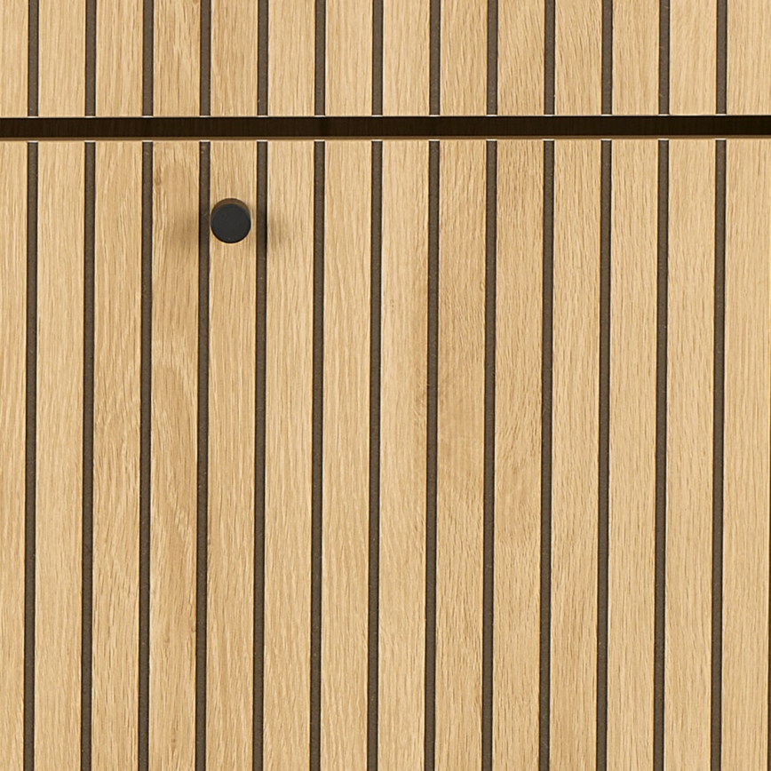 Drevená skrinka s vertikálnymi svetlohnedými lištami oddelenými tmavými čiarami má na sebe okrúhlu čiernu kľučku.