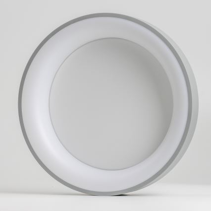 Okrúhle svietidlo s vnútorným bielym a vonkajším sivým kruhom je umiestnené na svetlom pozadí.