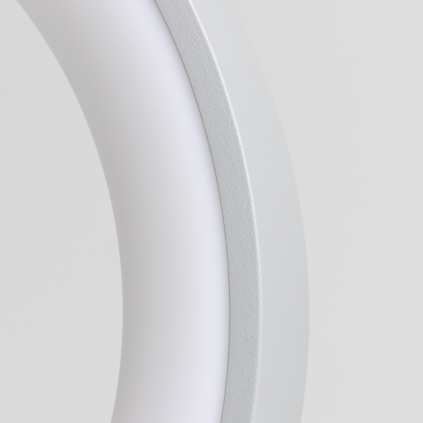 Svetlo šedá kruhová lampa s vnútorným bielym svetelným zdrojom sa nachádza na svetlom pozadí.