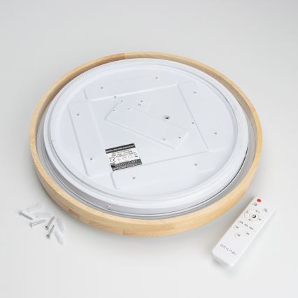 Drevené stropné svietidlo s bielym difúzorom leží na povrchu. K nemu patrí diaľkový ovládač ONILAGI a montážny materiál. Na difúzore je štítok s údajmi: MODEL: RR6505-50-WOOD, 220-240V~50/60Hz, 28W, IP20.