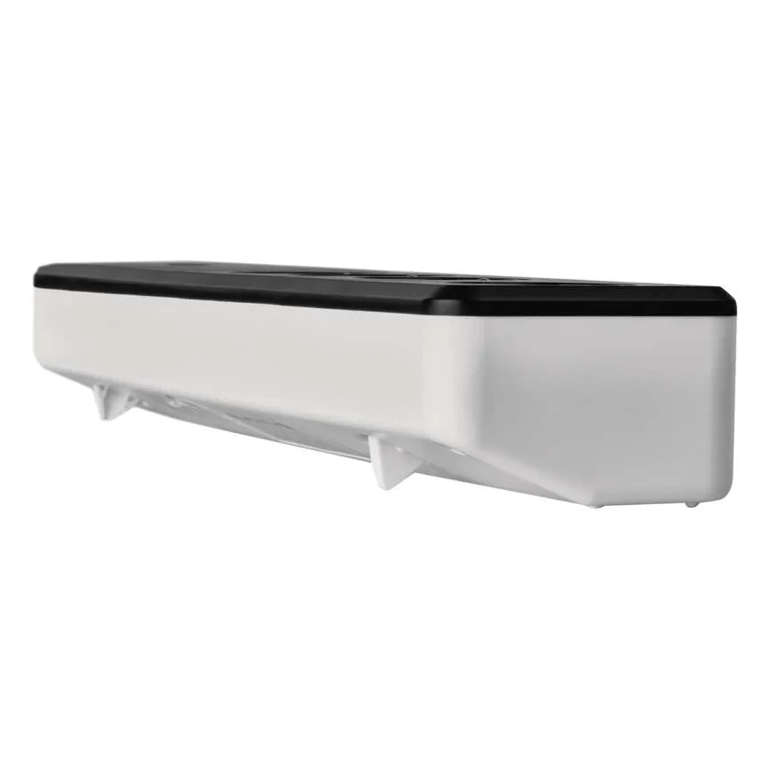 Dávkovač potravínarskej fólie je umiestnený na stene. Má biely plastový korpus s čiernym vrchnákom a štyrmi malými nožičkami na spodnej strane.