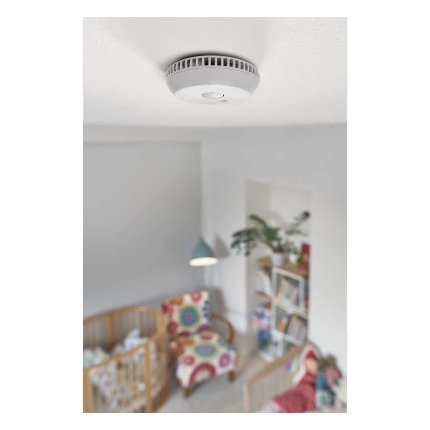Detektor dymu je pripevnený na strope detskej izby. Izba obsahuje detskú postieľku, kreslo a knižnicu.