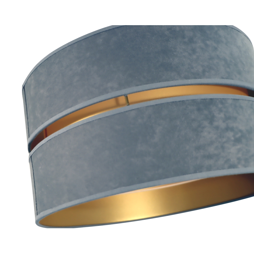Dvojvrstvový tienidlo visí. Tienidlo je sivomodrej zamatovej farby s vnútorným zlatým okrajom. Je zobrazené na bielom pozadí.