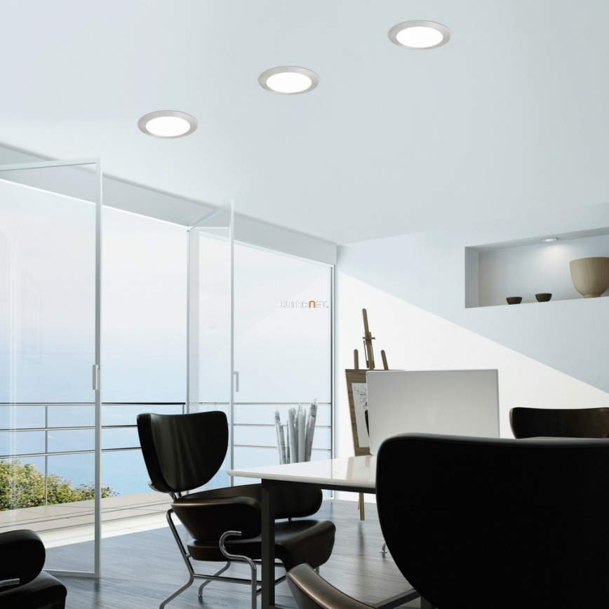 Tri kruhové svietidlá osvetľujú modernú kanceláriu s veľkými sklenenými dverami a výhľadom na more. V kancelárii sa nachádza stôl s kreslami a stojan na obrazy. Na stene je vidieť logo „LIGHTNET“.