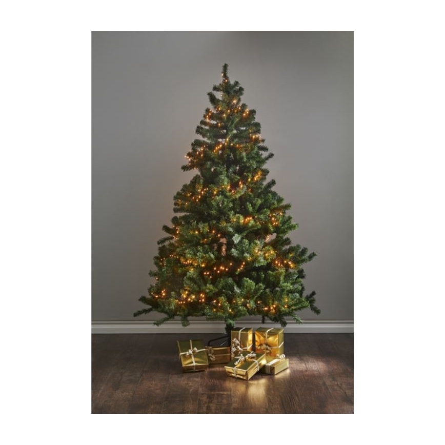 Vianočný stromček s teplými svetielkami je osvetlený. Stromček stojí na tmavej podlahe, okolo neho sú zlaté darčeky.