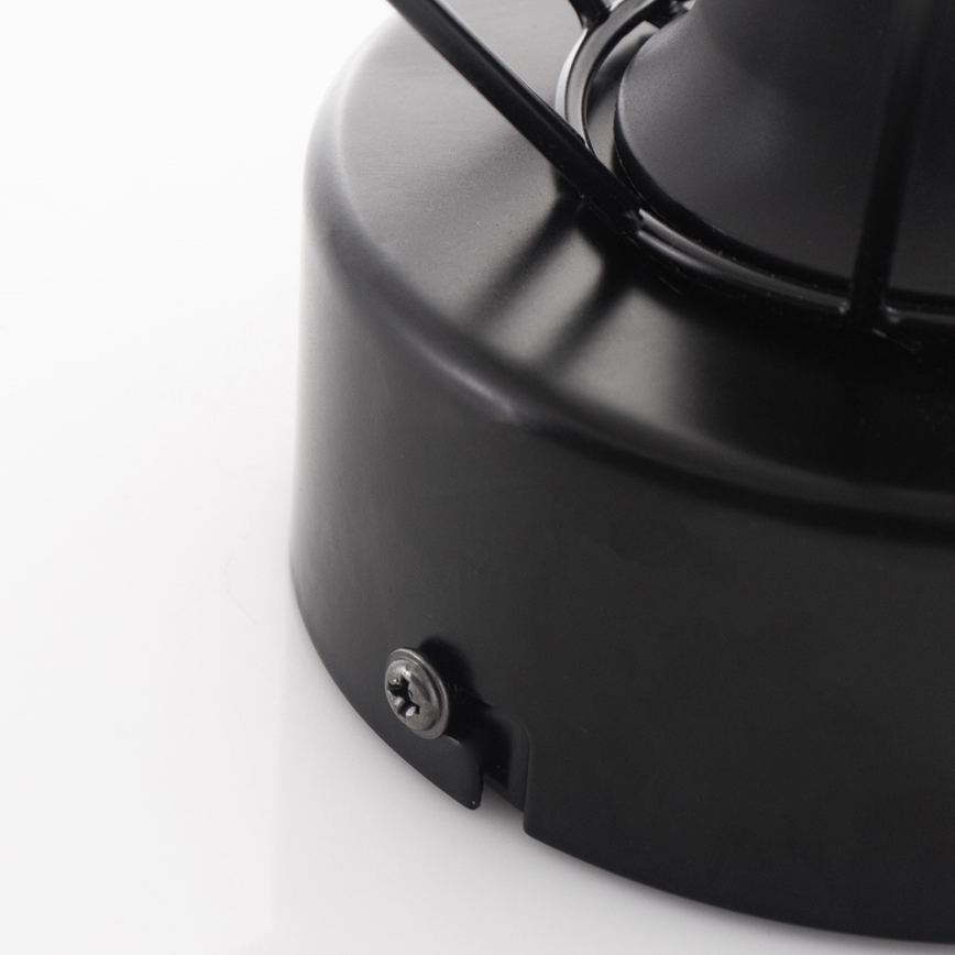 Čierna kovová základňa drží lampu. Základňa je pripevnená skrutkou. Biela plocha tvorí pozadie.