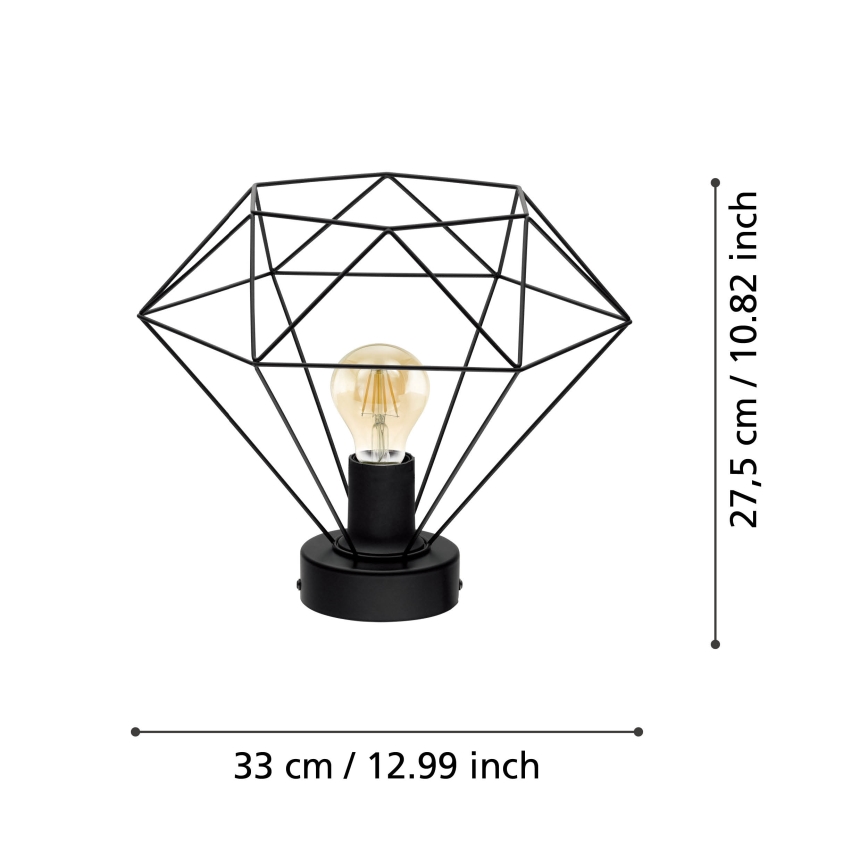 Stolová lampa s geometrickým tienidlom v tvare diamantu svieti. Tienidlo je z čierneho kovu, lampa je vysoká 27,5 cm a široká 33 cm.