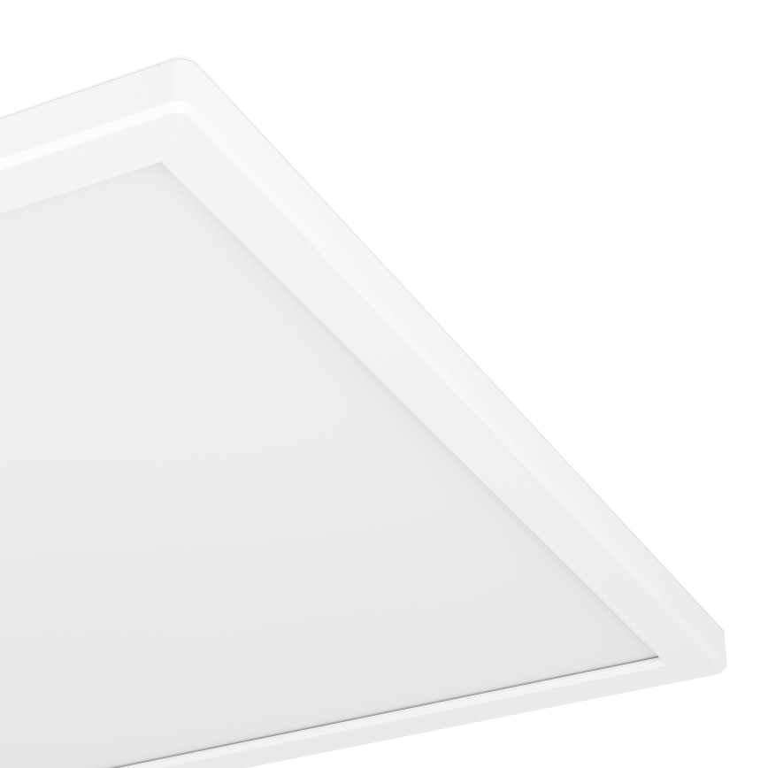 Biela štvorcová LED panelová lampa je pripevnená k stropu. Lampa je osvetlená a má biely rám. Pozadí je biele.