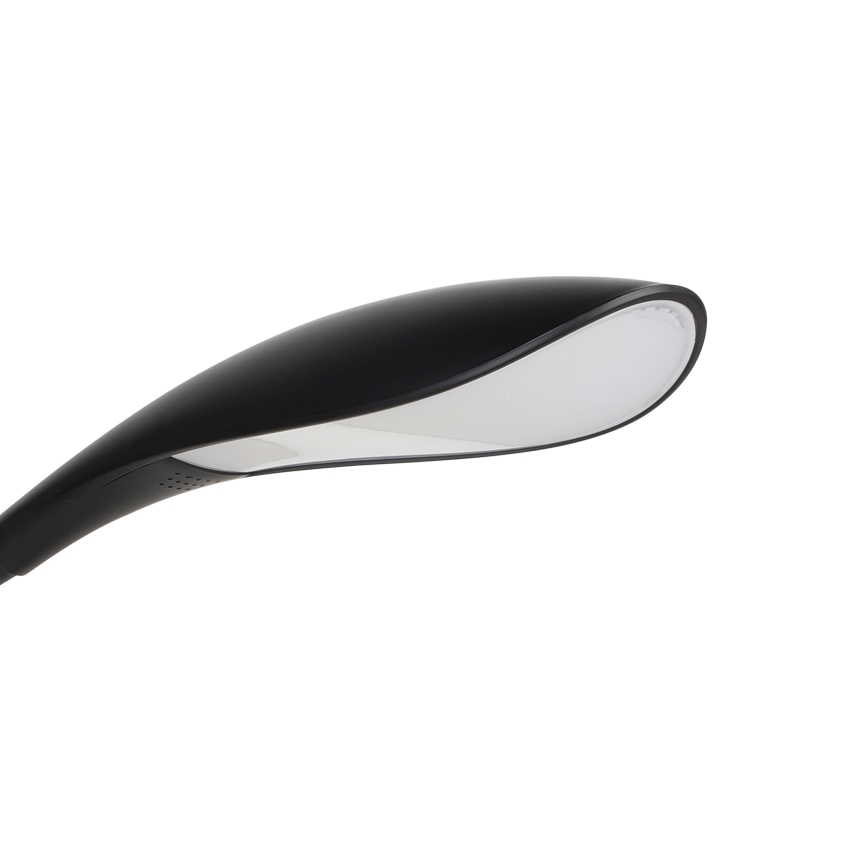 Stolová lampa s čiernym telom a bielym difúzorom svieti. Lampa je zakrivená a má moderný dizajn. Je umiestnená na bielom pozadí.