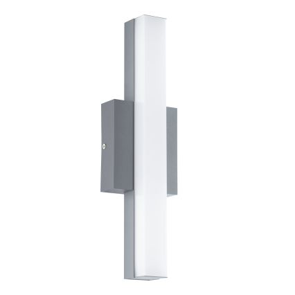 Svietidlo je pripevnené na stene. Má vertikálne orientované svetlo s mliečnobielym difúzorom a sivým kovovým rámom.