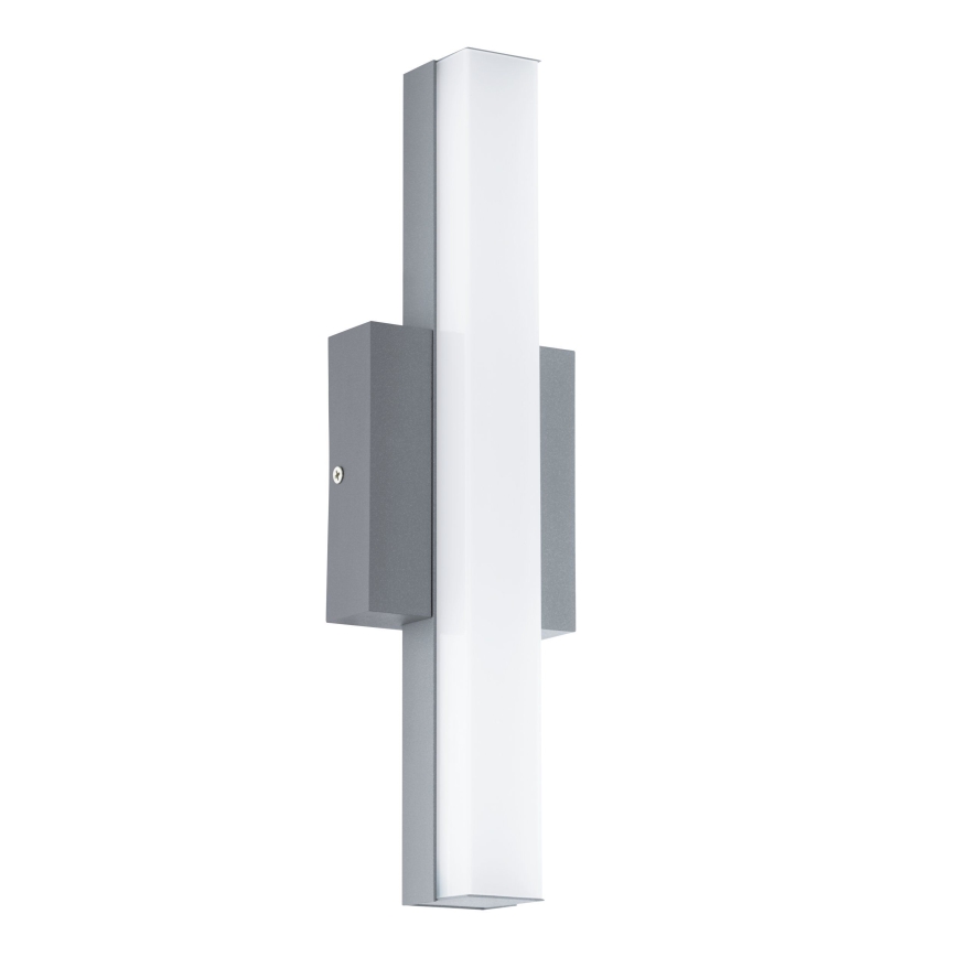 Svietidlo je pripevnené na stene. Má vertikálne orientované svetlo s mliečnobielym difúzorom a sivým kovovým rámom.