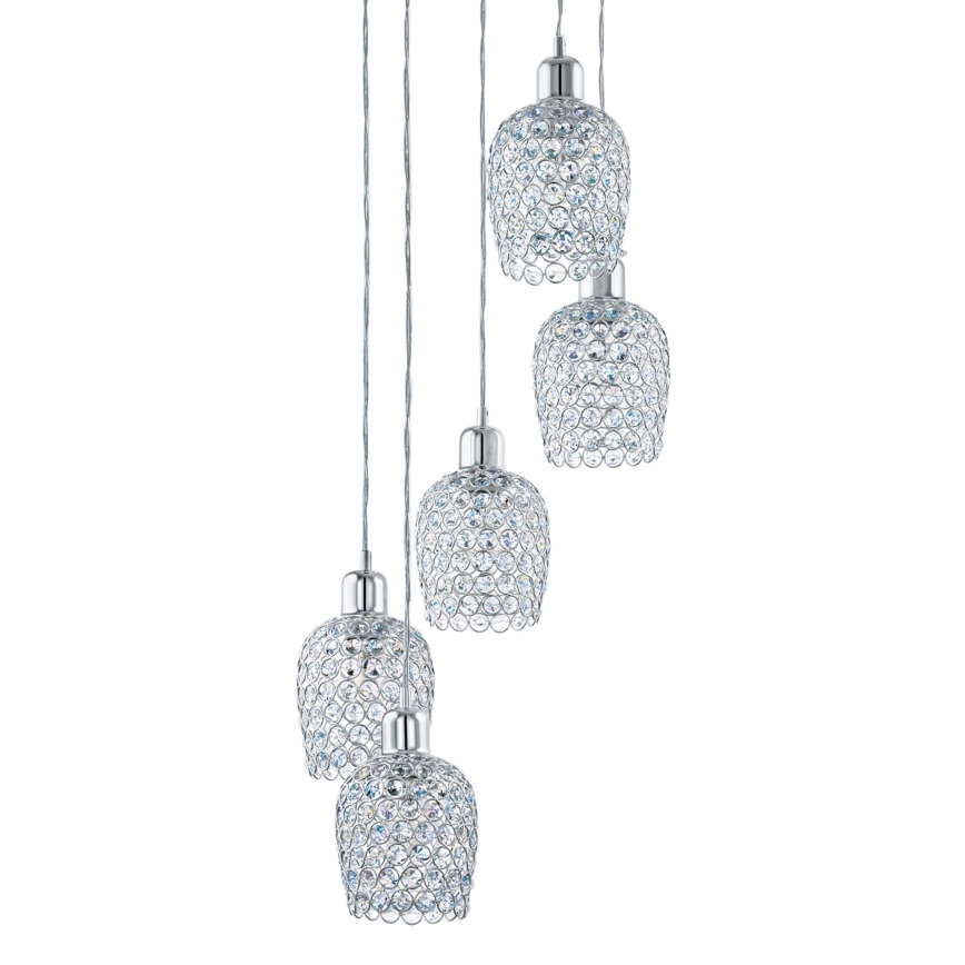 Piäťdielna luster visí zhora. Každý tienidlo je z chrómovaného kovu s priehľadnými krištáľovými ozdobami. Tienidlá sú usporiadané asymetricky.