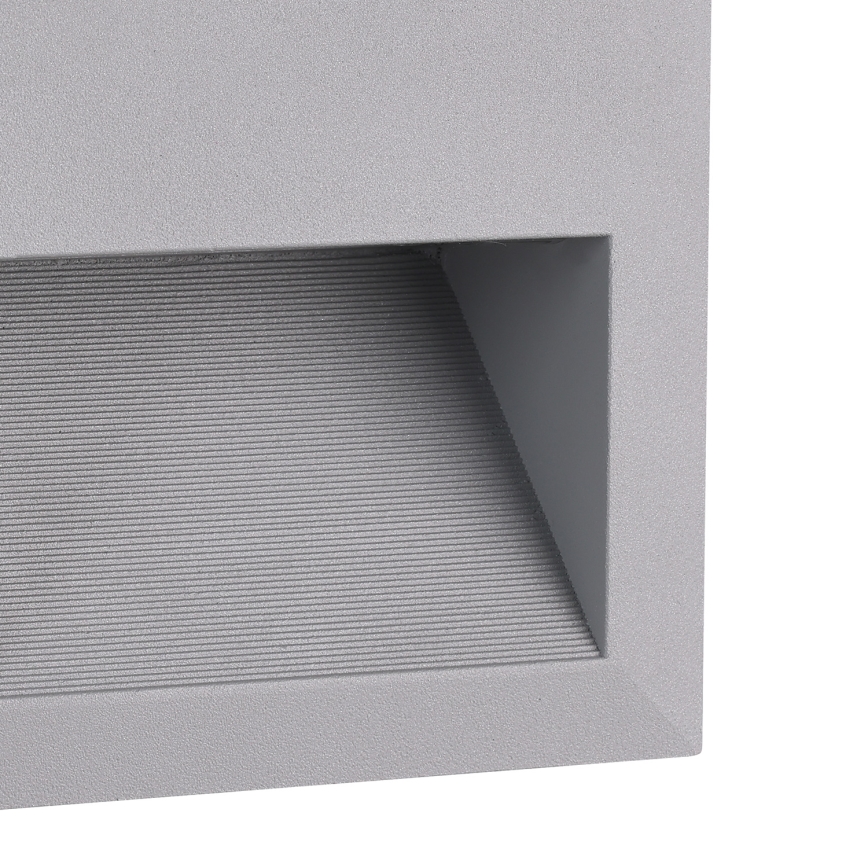 Svietidlo svieti. Je umiestnené v šedej obdĺžnikovej konštrukcii s ryhovaným povrchom.