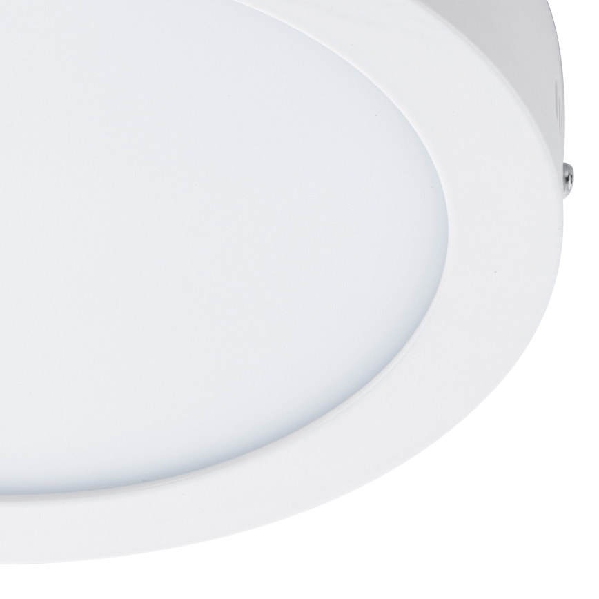 Biela LED diódová lampa s okrúhlym difúzorom je pripevnená k stropu. Svietidlo je zapustené do stropu.