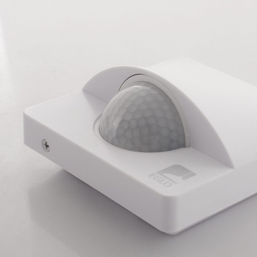 Senzor pohybu detekuje pohyb. Je zabudovaný v bielom štvorcovom puzdre s nápisom „EGLO“. Nachádza sa na svetlom povrchu.