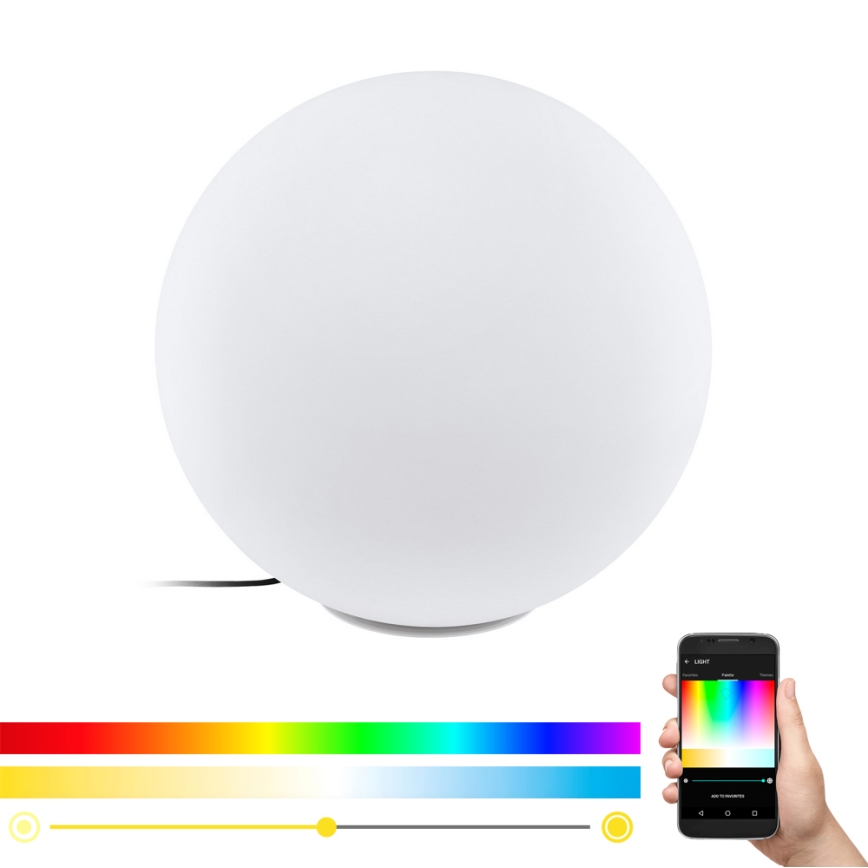 Guľová stolová lampa svieti. Lampa sa ovláda cez mobilnú aplikáciu, ktorá zobrazuje farebnú paletu a posuvníky pre nastavenie jasu a teploty svetla.