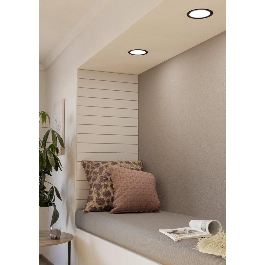 Tri vstavané bodové svetlá svietia v kľudnej výklenkovej sedačke s dvoma vankúšmi a časopisom.