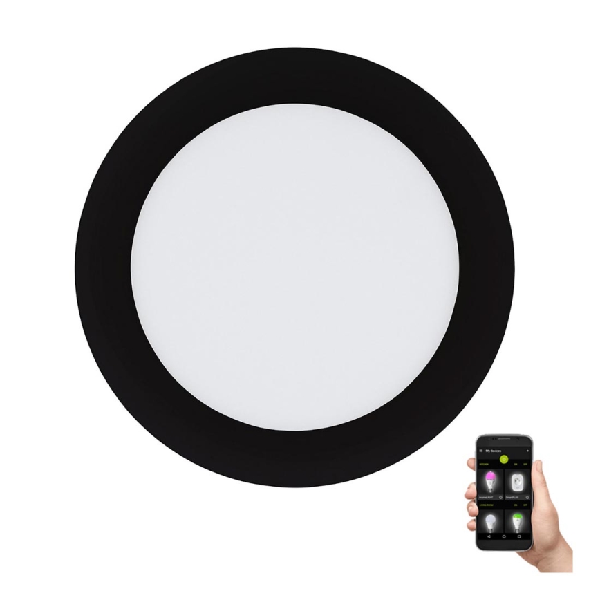 Okrúhle stropné LED svetlo s čiernym rámom je ovládané smartfónom. Aplikácia na telefóne zobrazuje rôzne svetelné režimy. Svetlo je umiestnené na bielom pozadí.