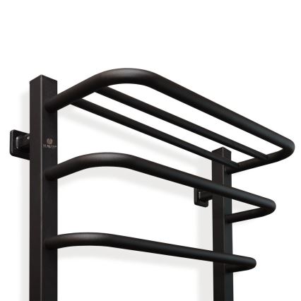 Držiak na uteráky je pripevnený na stenu. Má tri horizontálne tyče s mierne zaoblenými koncami na zavesenie uterákov. Je vyrobený z čierneho kovu. Na bočnej strane je viditeľné logo „HAUTZ“.