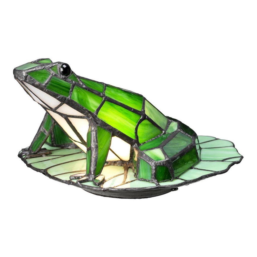 Zelená sklenená žaba, tvarovaná ako lampa, sedí na liste. Lampa je zložená z farebných sklenených dielikov.