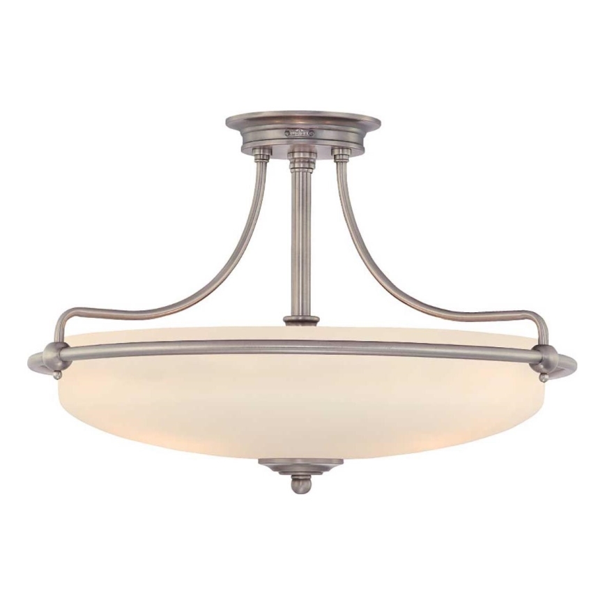 Stropné svietidlo s mliečnym tienidlom, ktoré je osvetlené. Svietidlo má kovový, strieborný rám. Je umiestnené na bielom pozadí.