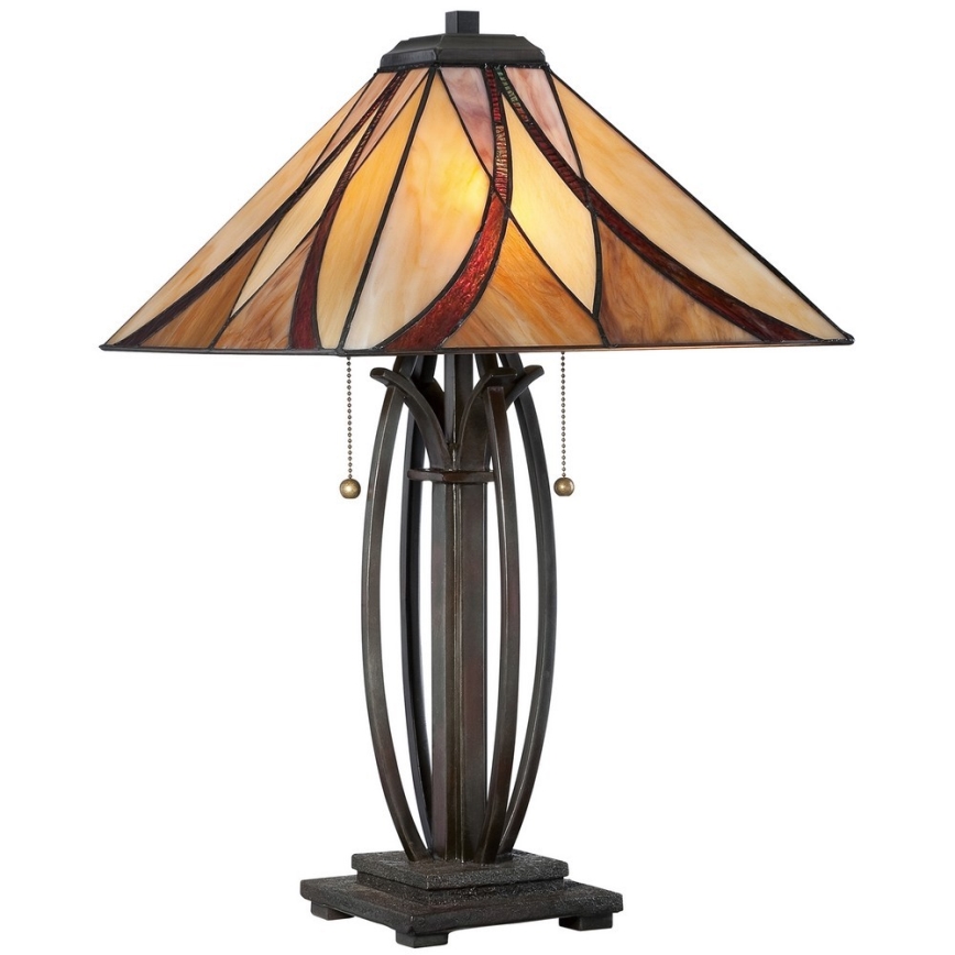 Stolová lampa s tienidlom z farebného skla, s kovovou nohou, stojí na štvorcovej podstave. Tienidlo má béžové, hnedé a červené odtiene. Lampa má dva retiazkové vypínače.