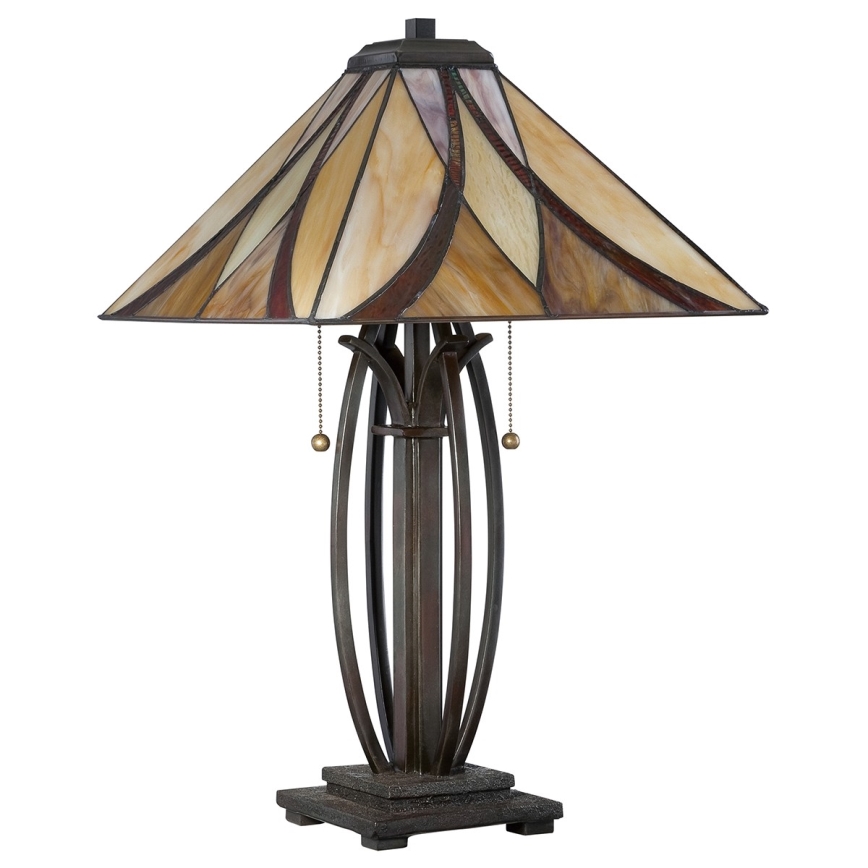 Stolová lampa s tienidlom z farebného skla stojí na štvorcovom podstavci. Tienidlo je zložené z hnedých, béžových a červenkastých častí. Noha lampy je kovová, tmavohnedá s ozdobnými prvkami.