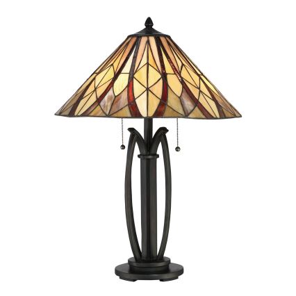 Stolová lampa s tienidlom z vitrážového skla v béžových a červenohnedých odtieňoch, s kovovou podstavou v tmavšej hnedo-čiernej farbe. Lampa stojí na bielom pozadí.