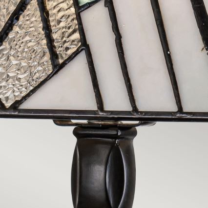 Stolová lampa s tienidlom z opálového a strieborného skla v geometrickom vzore, spojená s čiernou kovovou základňou v tvare valca.