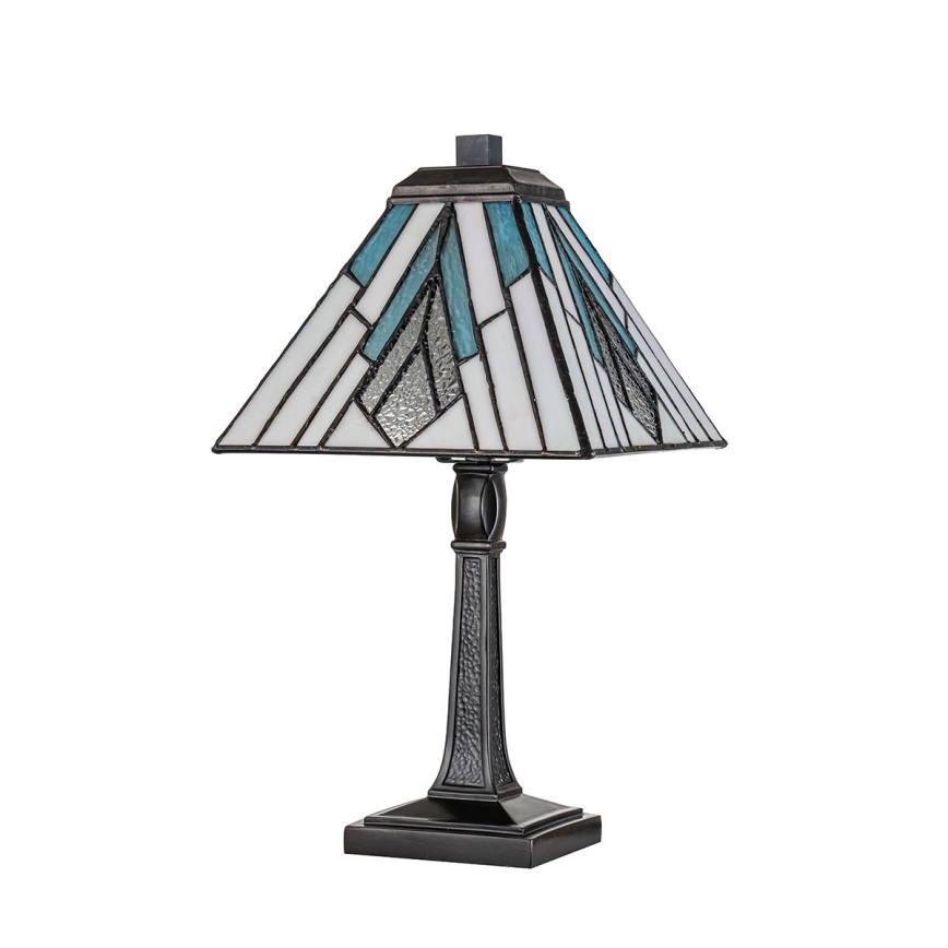 Stolová lampa s štvorcovým tienidlom z vitráže v modro-bielych odtieňoch stojí na tmavohnedej kovovej nohe. Lampa je umiestnená na bielom pozadí.